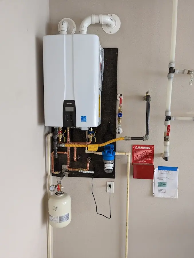 Professional plumber installing copper piping in a College home